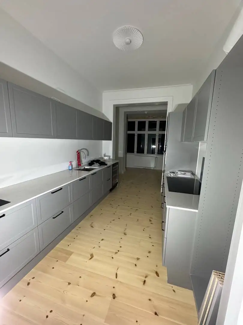Totalrenovering Skodsborg — nyt grå HTH-køkken med pinegulv