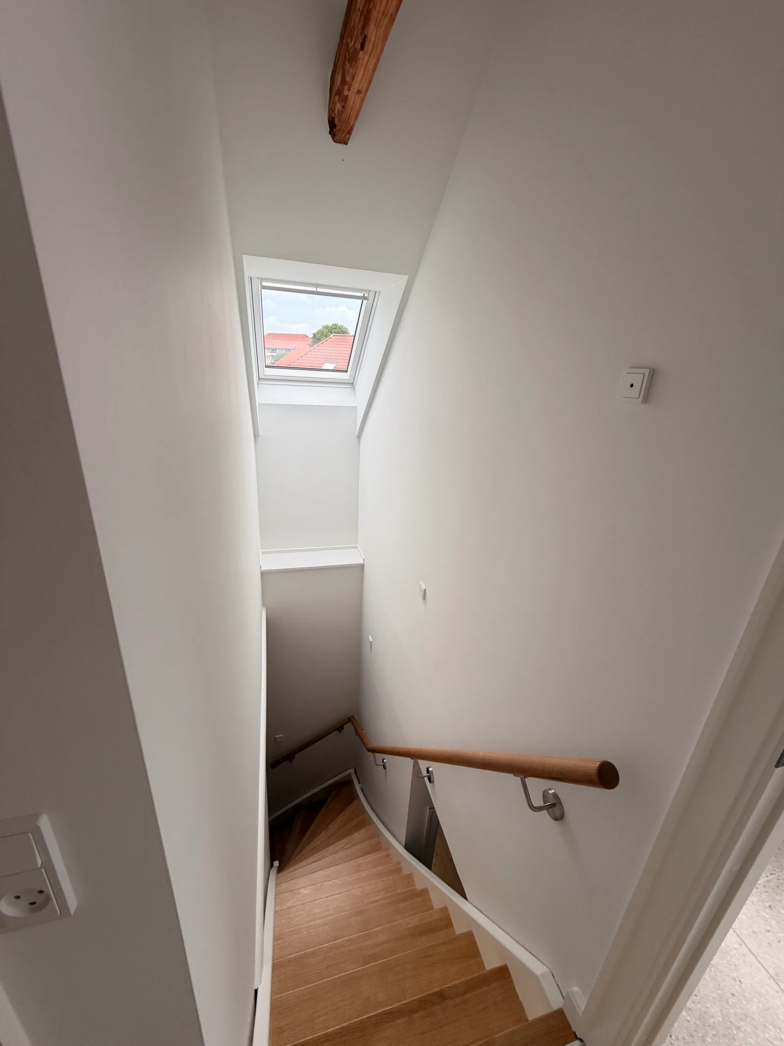 Ny 1. sal Brønshøj — trappen set oppefra med ovenlysvindue og udsigt over nabotagene